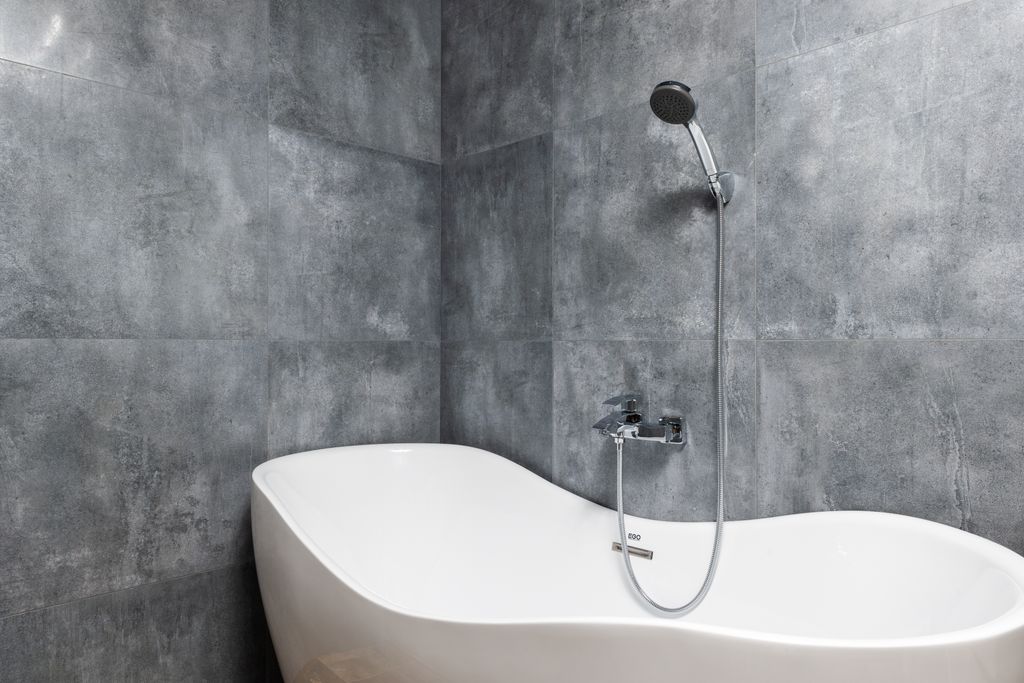 Bañera con ducha cuyas juntas desgastadas pueden filtrar agua al piso de abajo